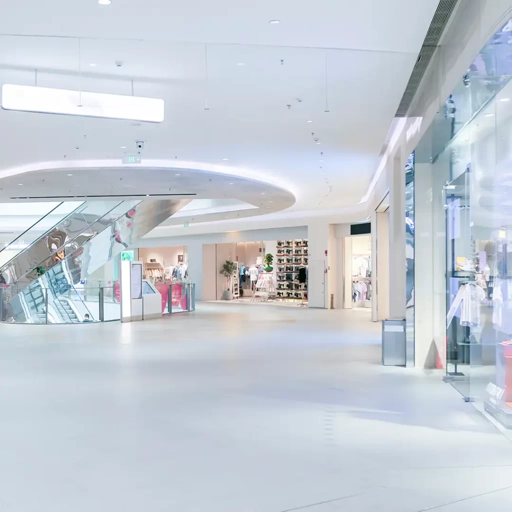 A shopping mall with a lot of people walking around.